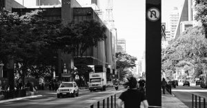 Vista do MASP e da Avenida Paulista com diversas pessoas transitando e alguns carros